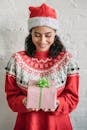 Smiling ethnic woman with Christmas gift decorated with bow