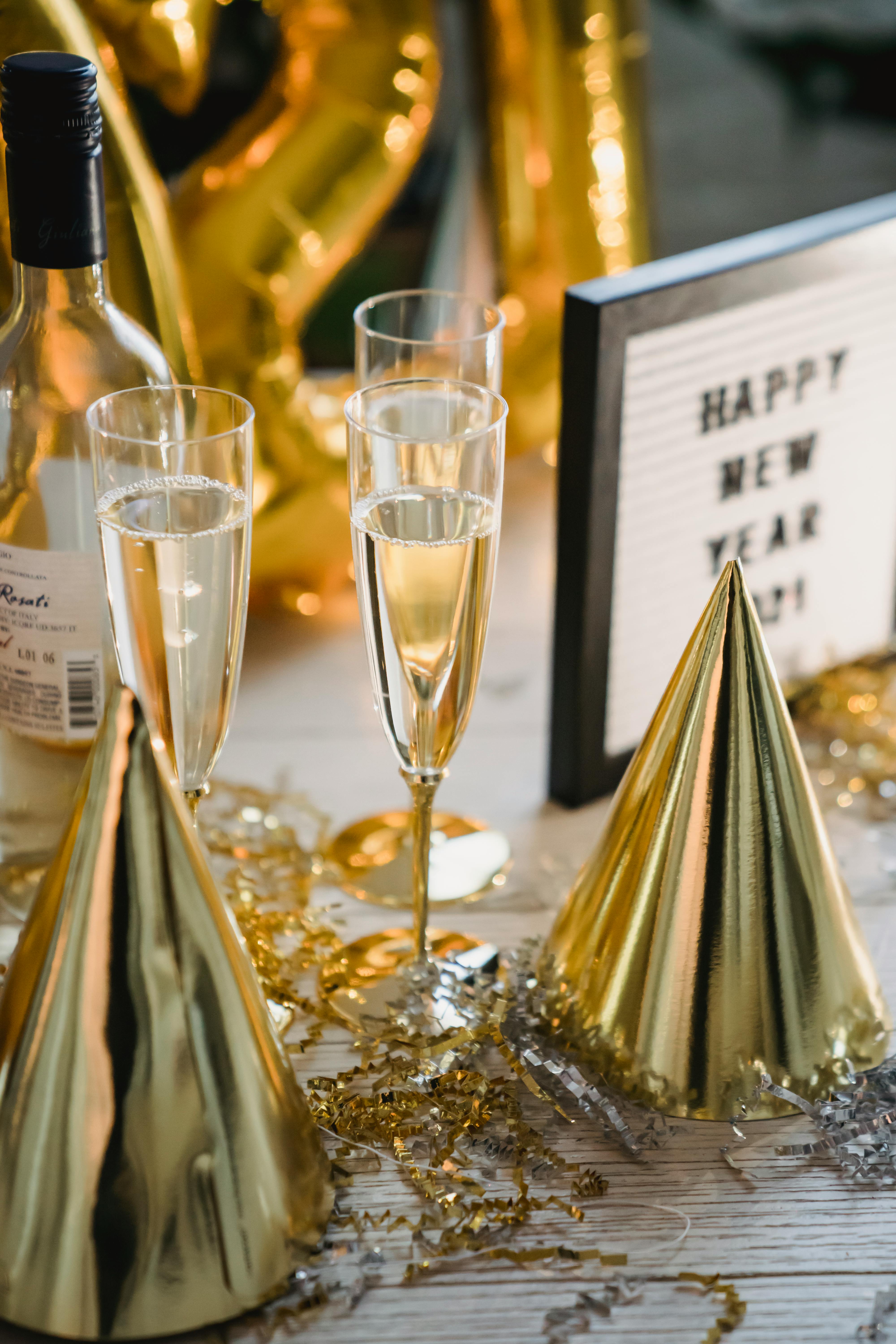 champagne glasses and bottle near festive new year decorations