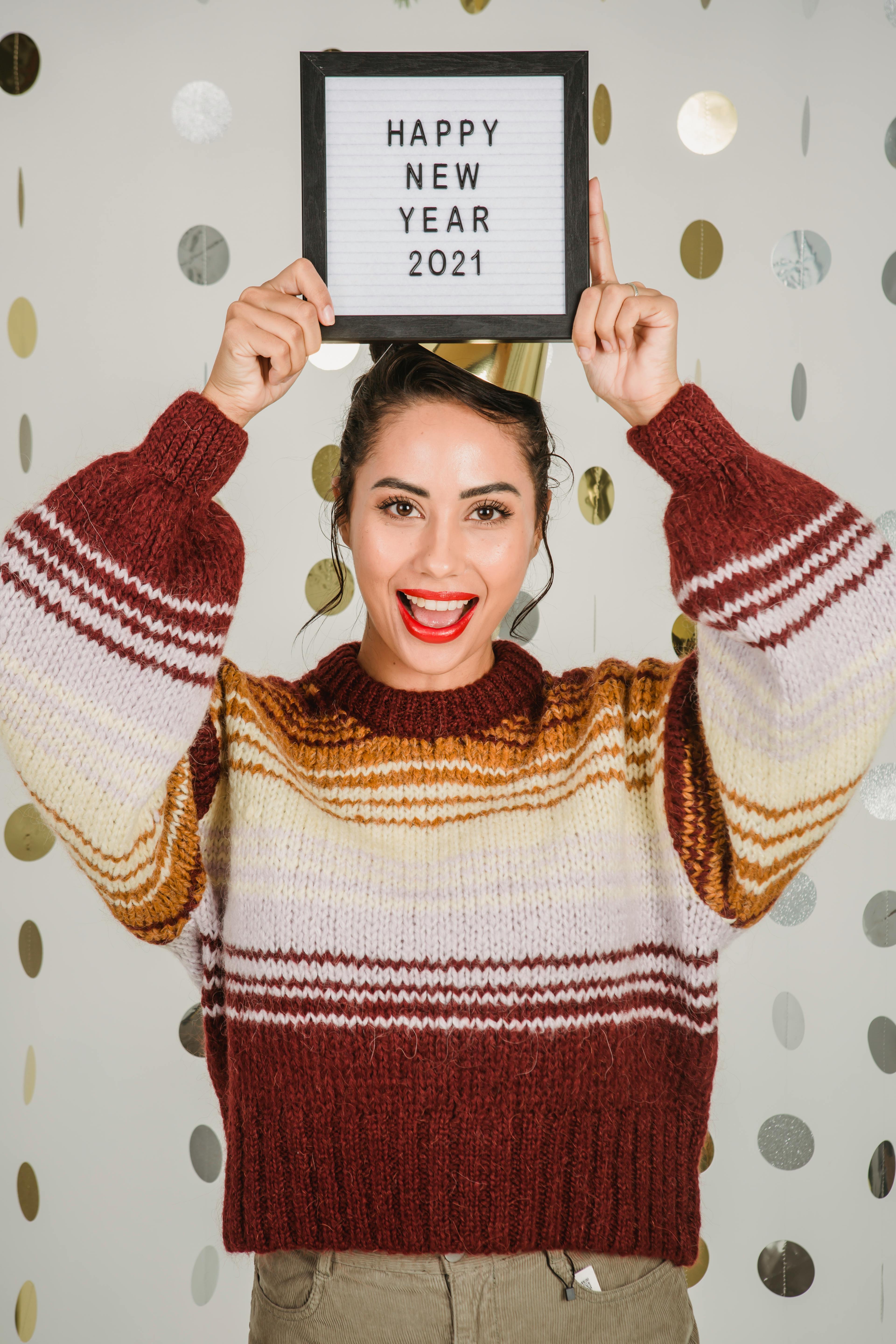 excited ethnic woman showing frame with congratulation of new year