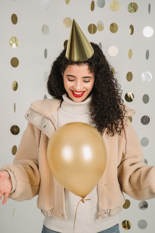 Smiling woman with balloon in decorated room