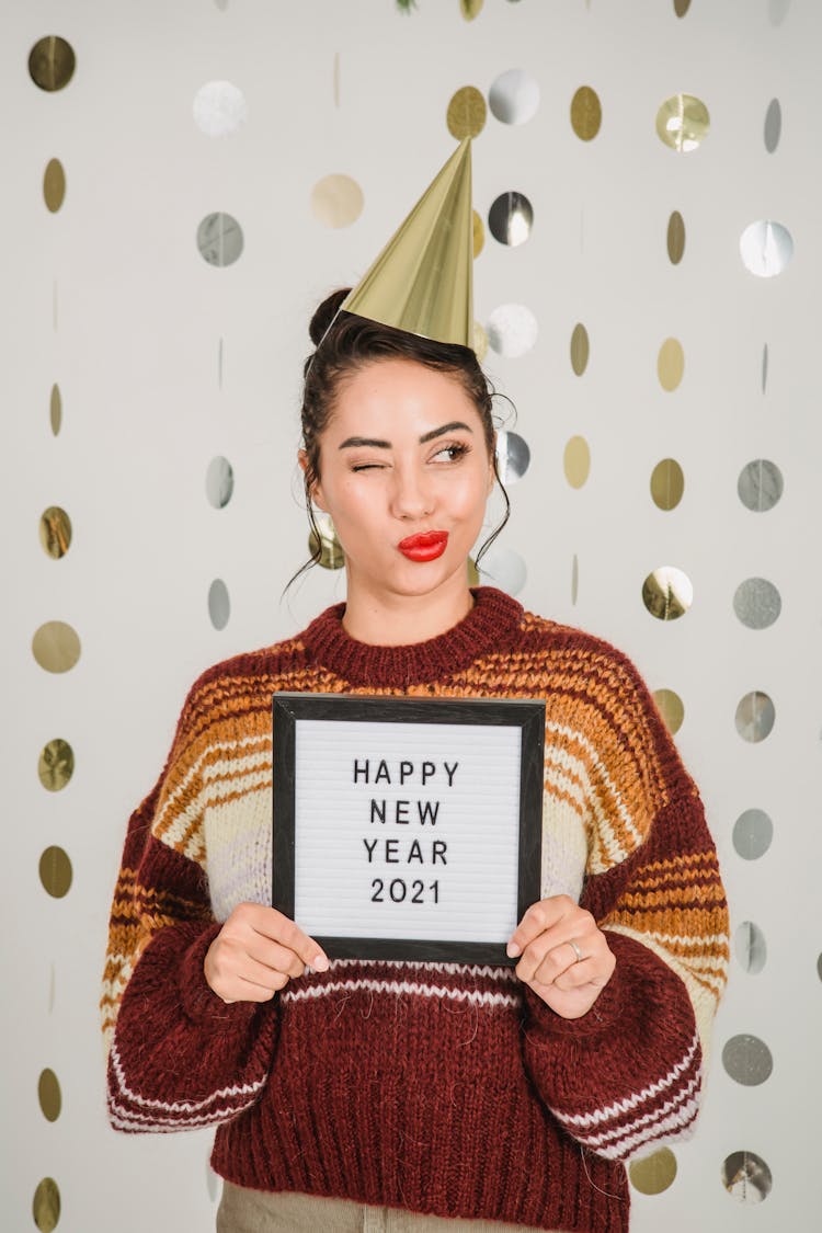 Ethnic Woman Winking While Showing Frame With New Year Congratulation