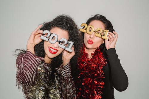 Happy women in decorative glasses 2021 and tinsel