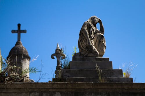 Woman Statue Near Cross during Daytime