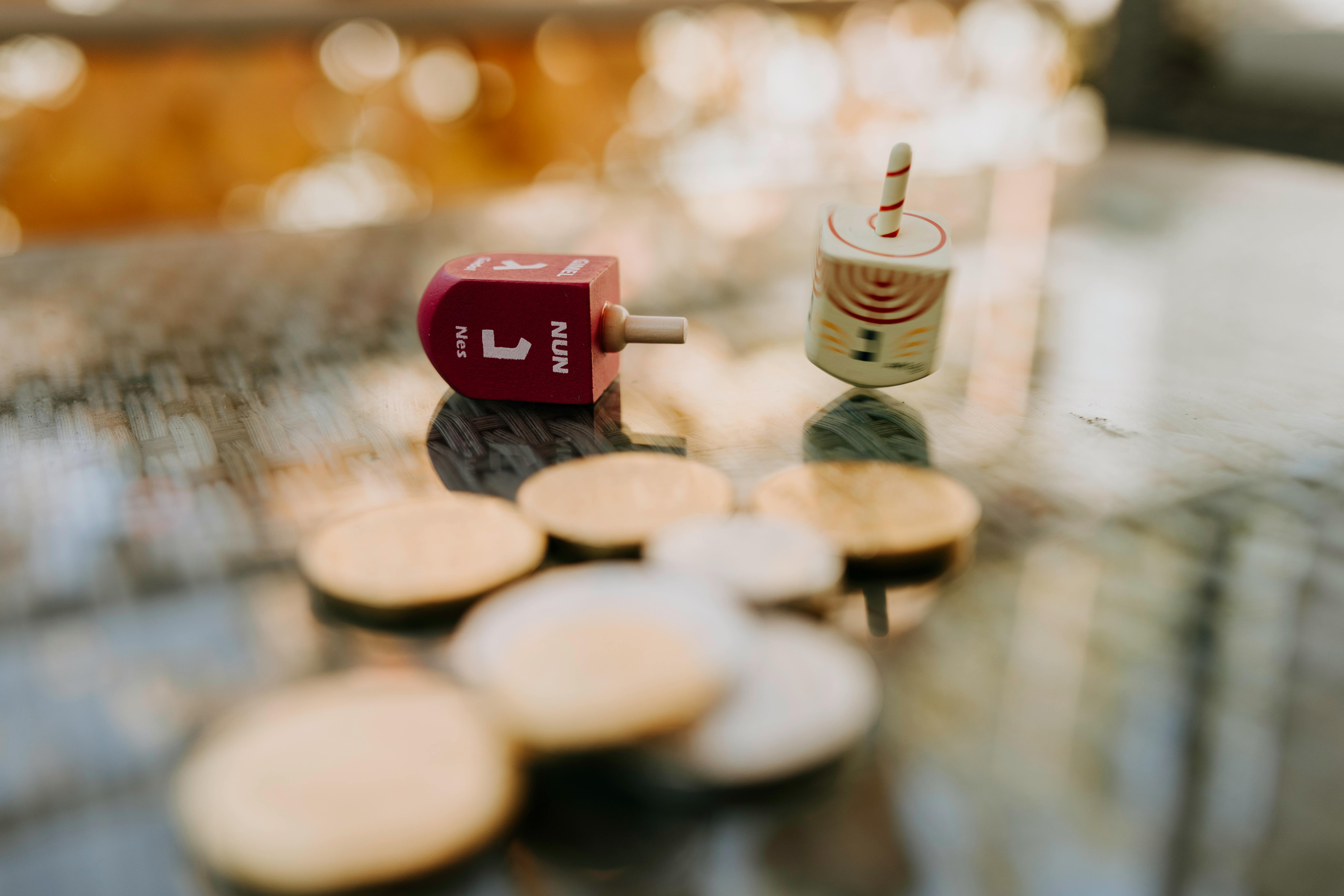 close up photo of gold coins near dreidel spinners