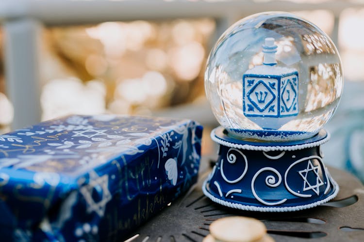 Close-Up Photo Of Snow Globe Beside Present