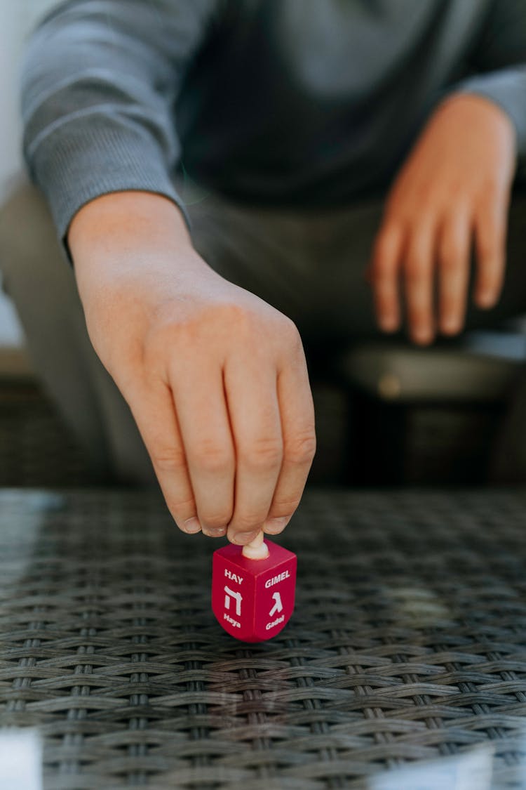 Photo Of Person Spinning A Dreidel 