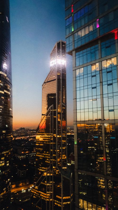 Free Contemporary skyscrapers with mirrored glass walls and reflection of cityscape located in Moscow city Russian Federation at sundown Stock Photo