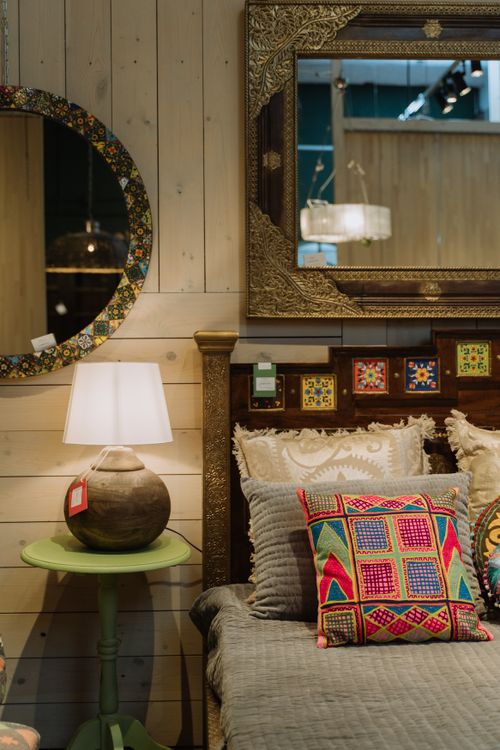 Free Cozy bedroom featuring bohemian decor with ornate mirrors, colorful cushions, and soft lighting. Stock Photo