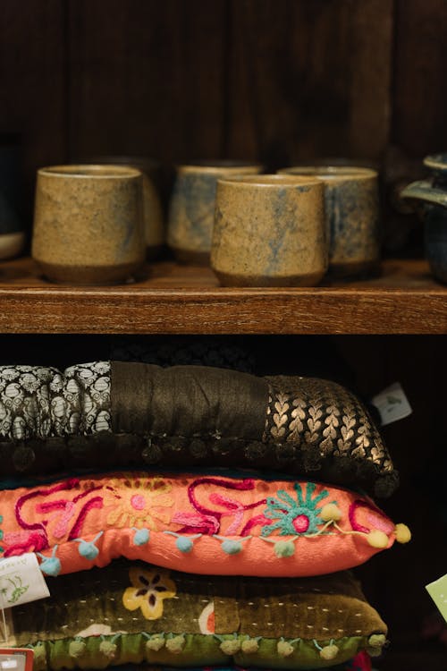 Ceramic Cups and Throw Pillows on Wooden Shelves