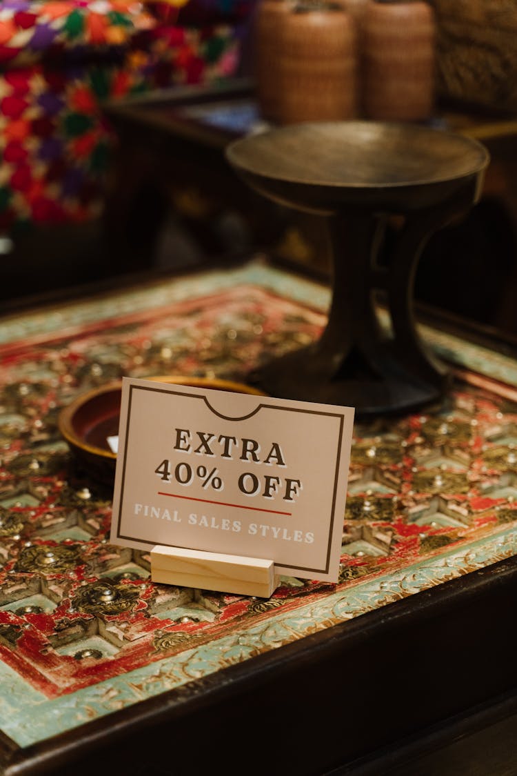 A Discount Sign On A Table In A Furniture Store