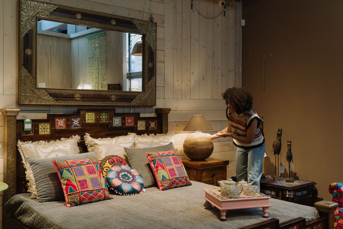 Round bedroom mirror creating a balanced focal point above the bed