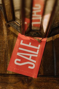 A red sale tag with bold white letters on a wooden surface, highlighting a Black Friday sale.