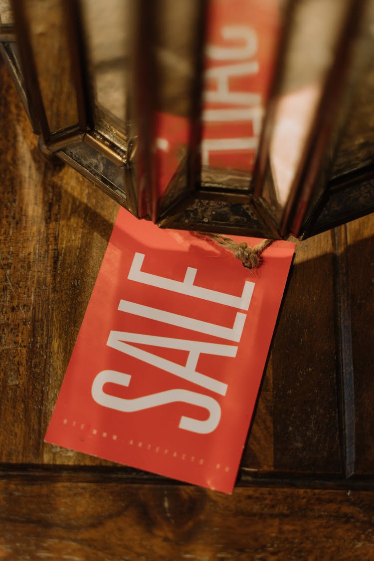 Red Sale Tag On A Wooden Surface