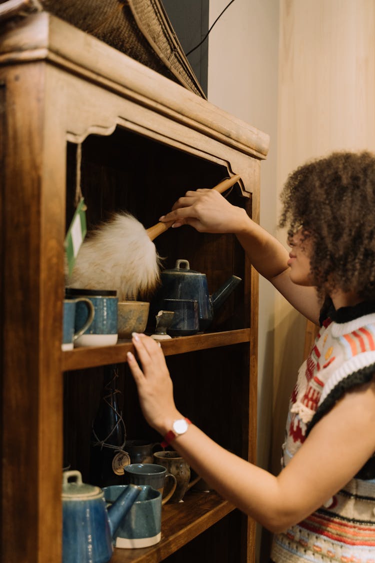 A Woman Dusting A Furniture