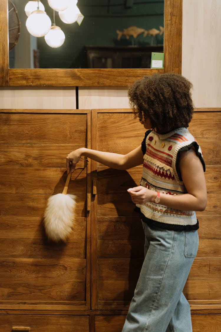 Woman Cleaning A Wooden Cabinet