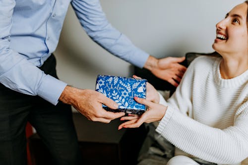 Foto Der Person, Die Geschenk An Frau übergibt