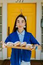 Photo Of Woman Holding Doughnuts On Brown Wooden Tray