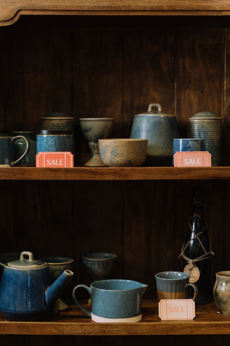 Sale Tags On Wooden Shelves With Assorted Pots