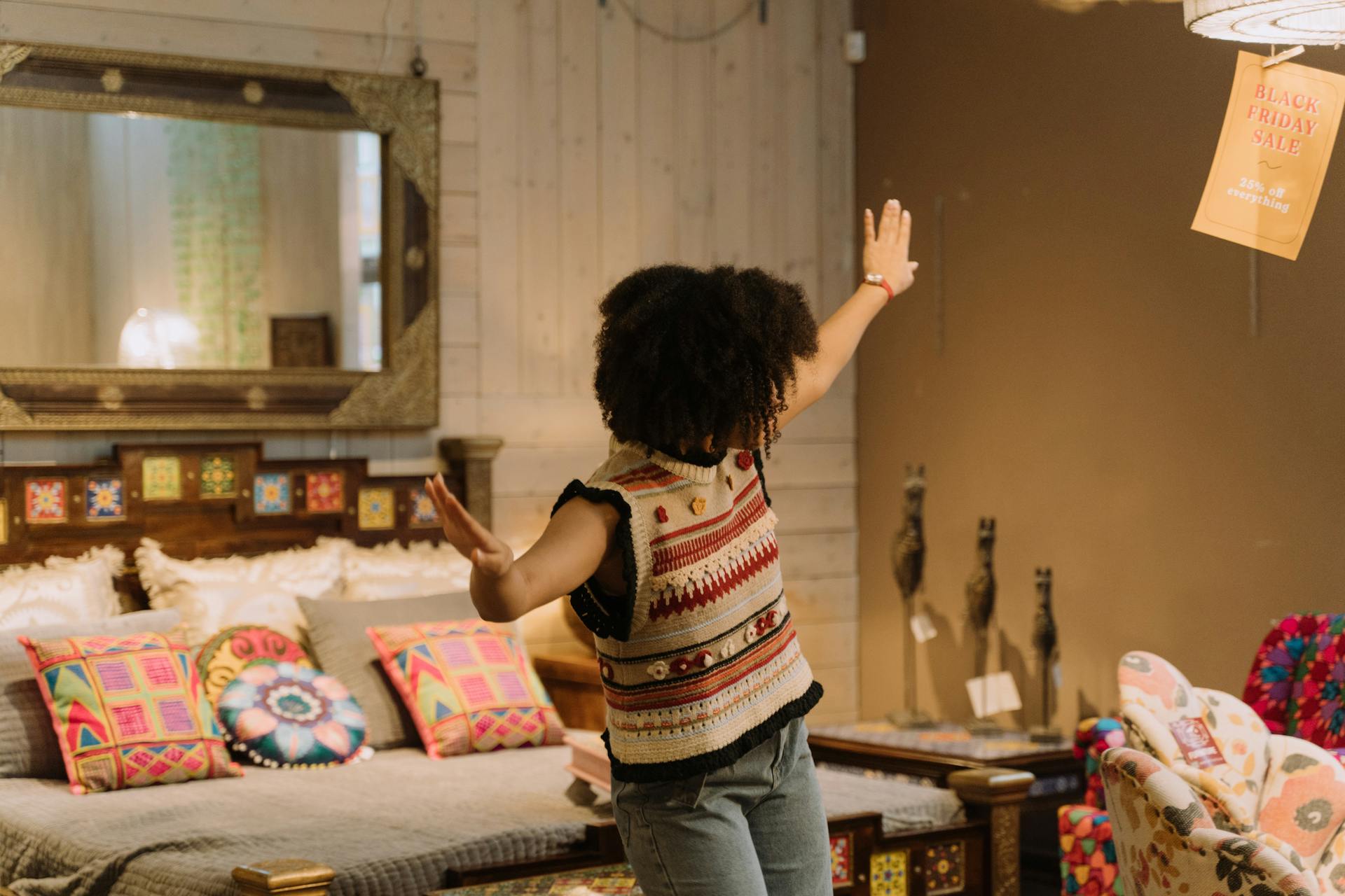 A young woman joyfully shopping during a Black Friday sale in a stylish home decor store.