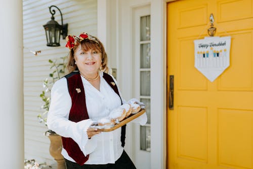 Photo Of Woman Holding A Tray Of Doughnuts