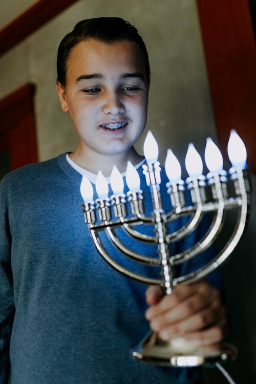 Photo Of Boy Holding A Candle Holder
