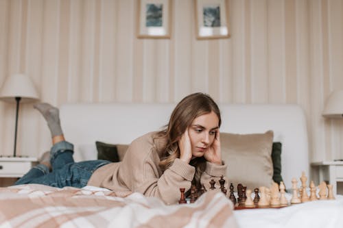 A Woman Playing a Game of Chess in the Bed