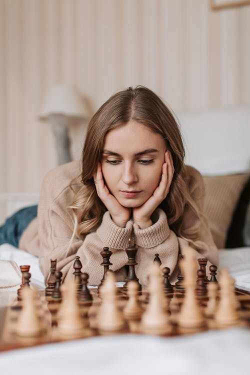Woman in Brown Long Sleeve Shirt Playing Chess