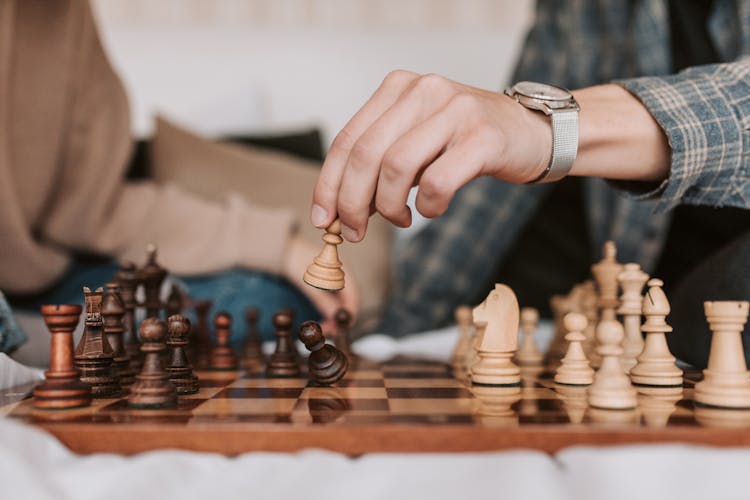 A Person Making A Move In A Chess Game