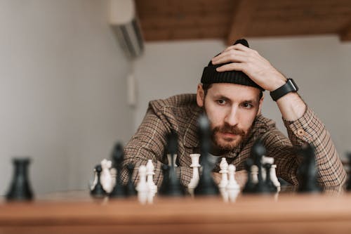 Free A Man in Checkered Shirt Playing Chess Stock Photo