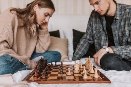 Free A young couple deeply focused on a chess game in a cozy indoor setting. Stock Photo