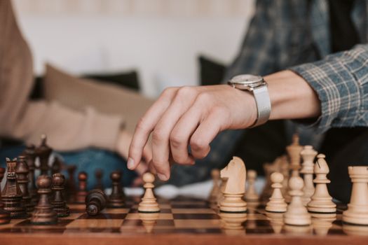 A person makes a strategic move in a chess game, highlighting the art of strategy.