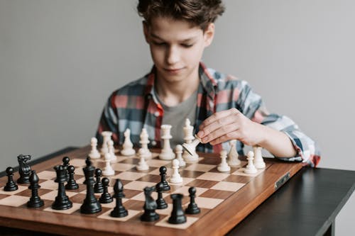 Free A Boy Playing a Game of Chess Stock Photo