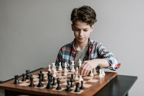 Free A Boy Making a Move in a Game of Chess Stock Photo