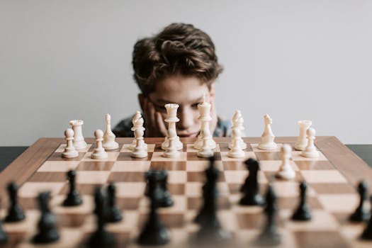 A young boy intensely focused on a chessboard, pondering his next strategic move indoors.