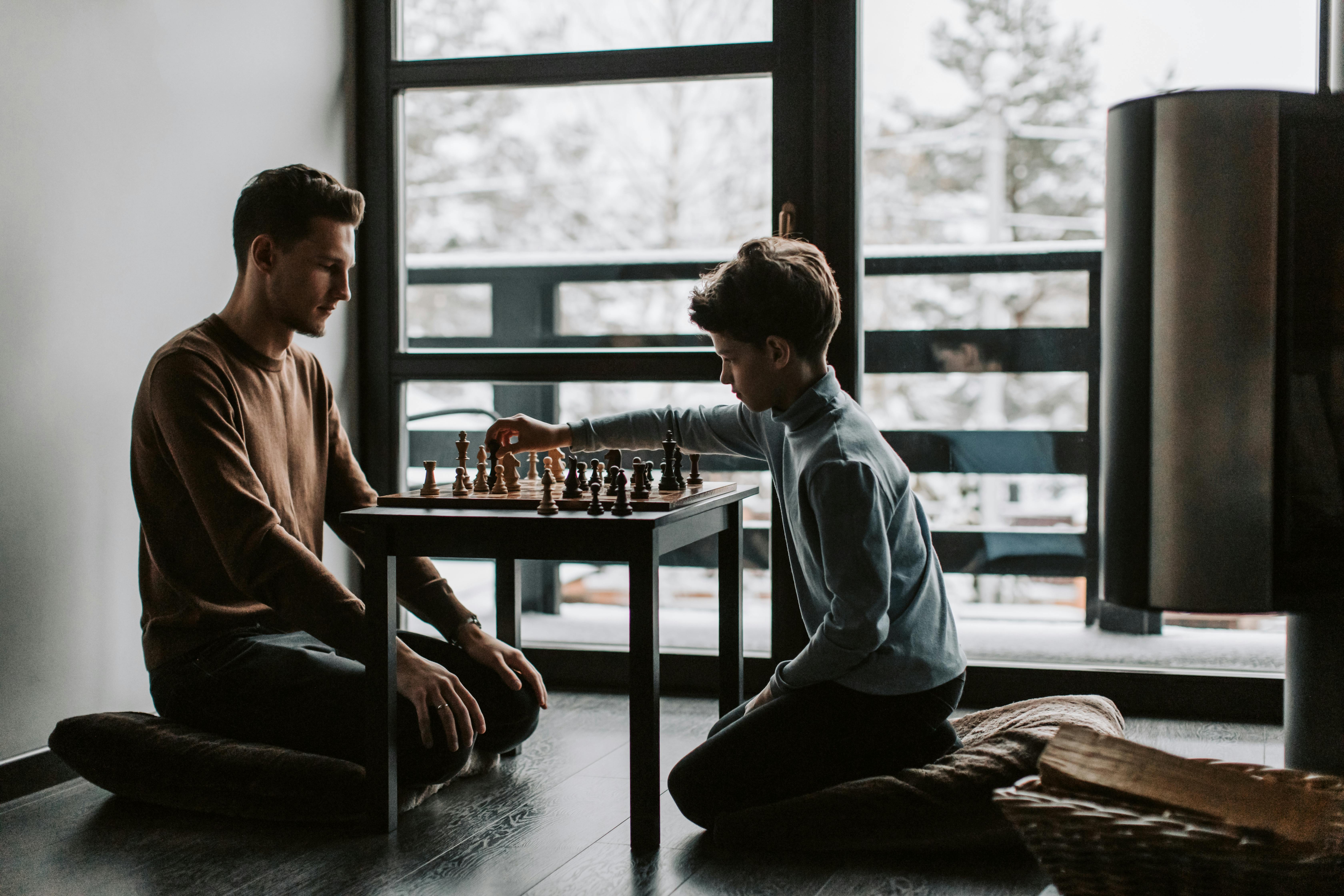 Two men sitting indoors playing a game of chess in hotel lounge Stock Photo  - Alamy