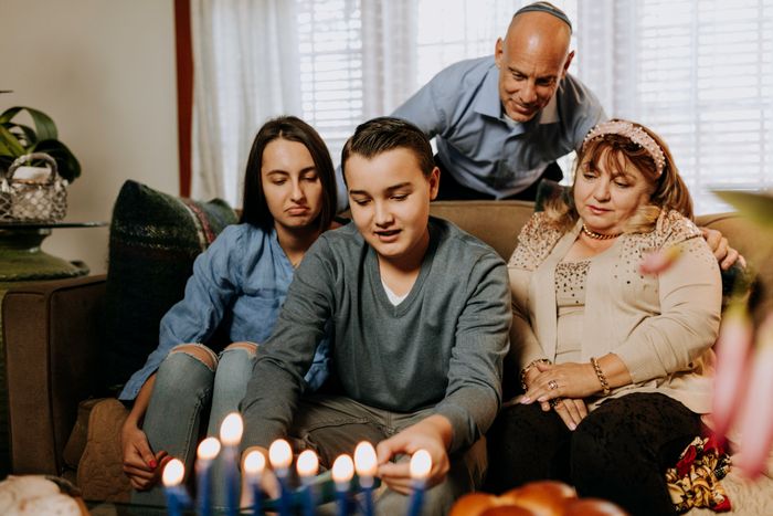Family lighting the menorah together