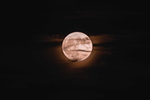 Picturesque scenery of clouds floating neat bright full moon shining in dark night sky