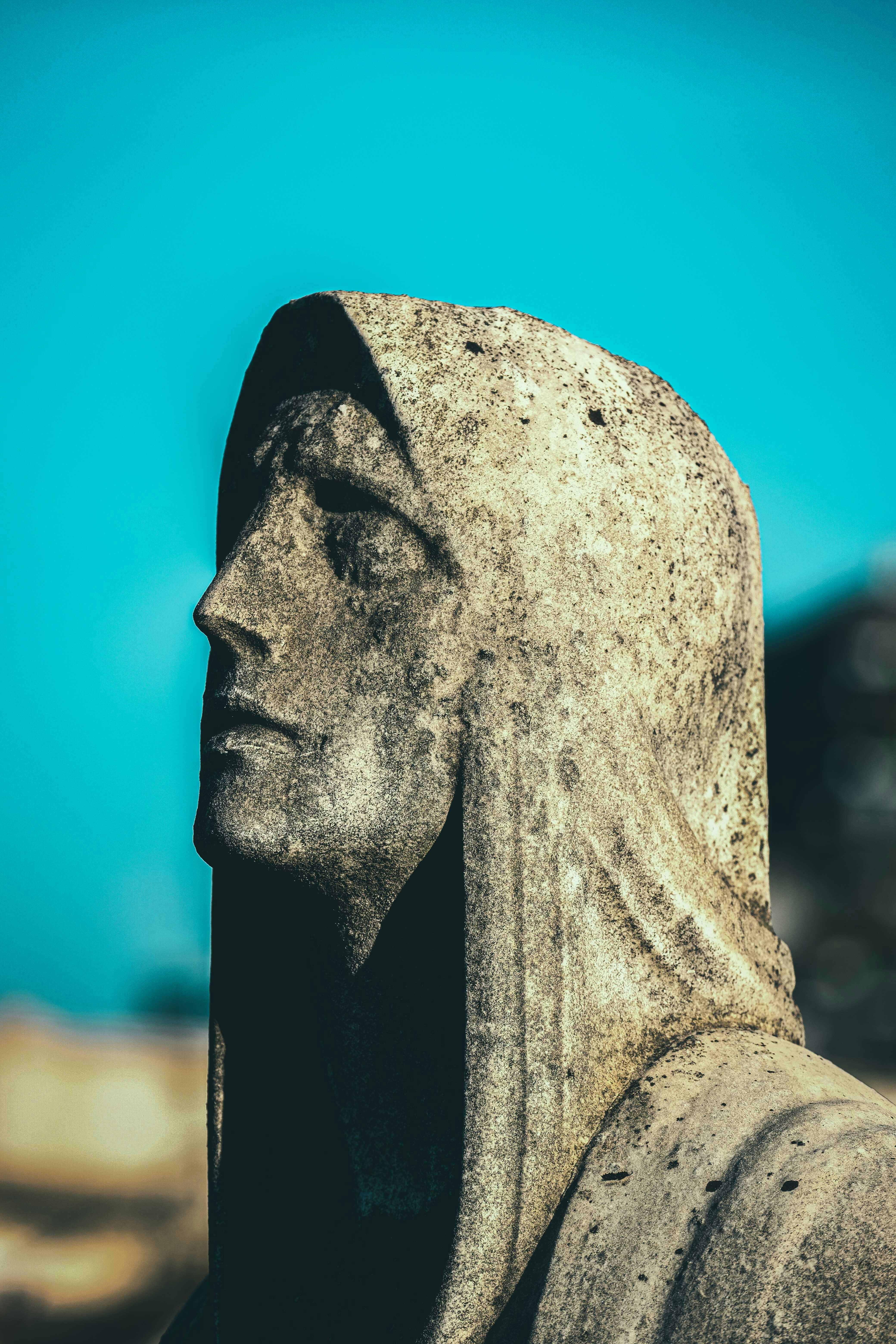 aged stone monument of woman under blue sky