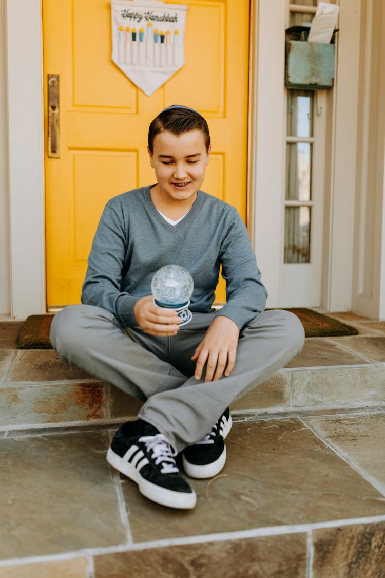 Photo Of Boy Holding A Snow Globe