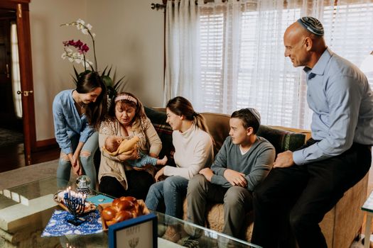 A Jewish family gathering together indoors to celebrate Hanukkah, showcasing love and tradition.