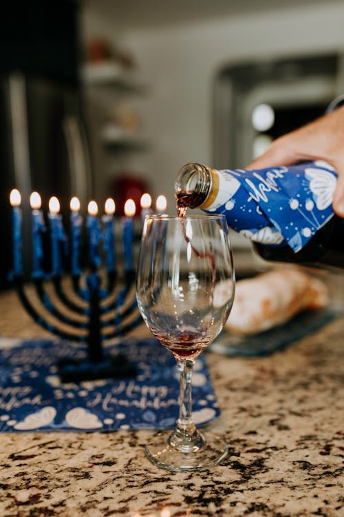 Foto Di Persona Che Versa Il Vino Sul Bicchiere Di Vino Chiaro