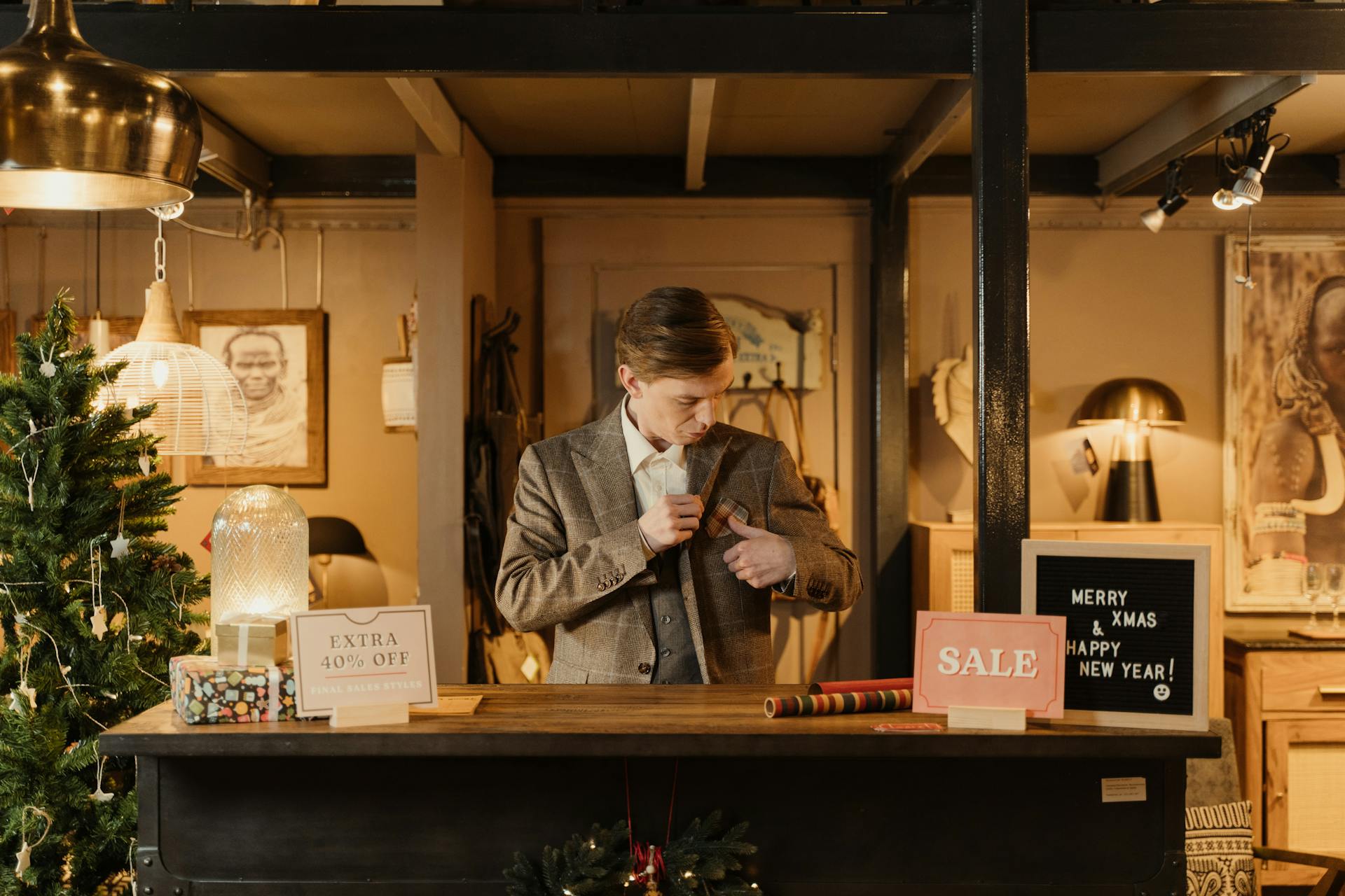 A salesman in a festive store setting, promoting a Christmas sale with seasonal decorations.