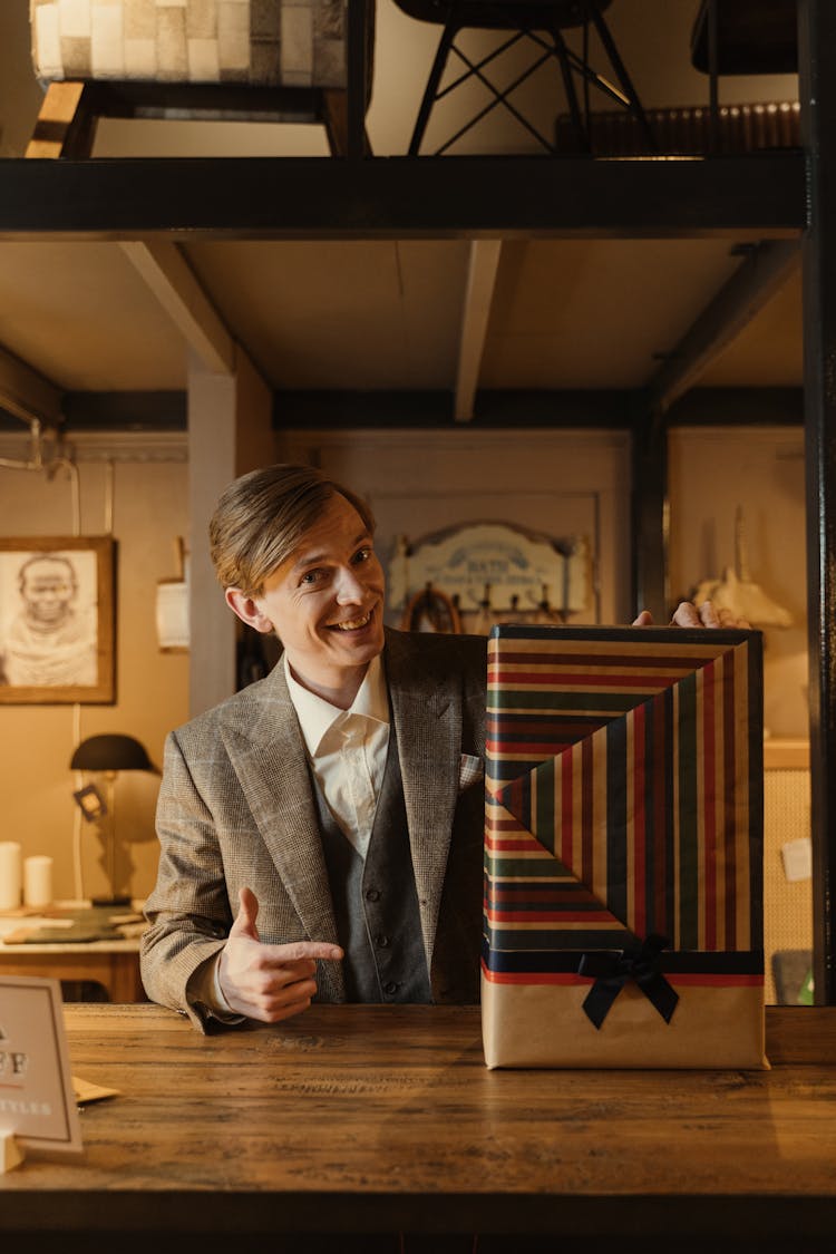 A Man In Business Suit Pointing To A Gift Box