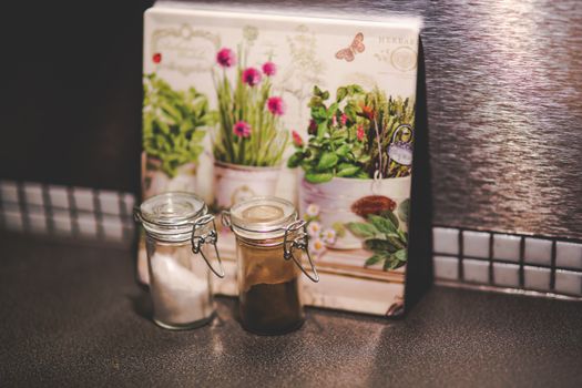 Aesthetic kitchen scene featuring herb artwork and glass spice jars, perfect for home decor inspiration.