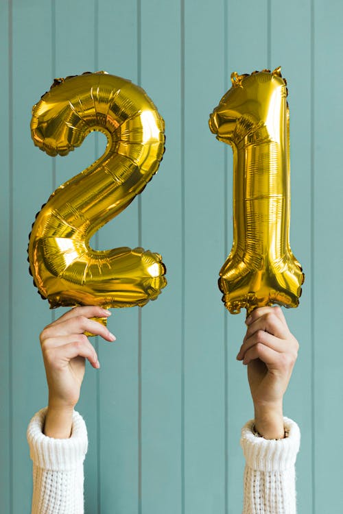 Free A Person Holding Gold Number Balloons Stock Photo