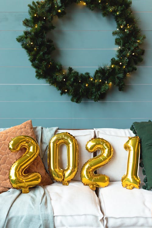 Free Сhristmas Wreath on Wall and 2021 Balloons on Sofa Stock Photo