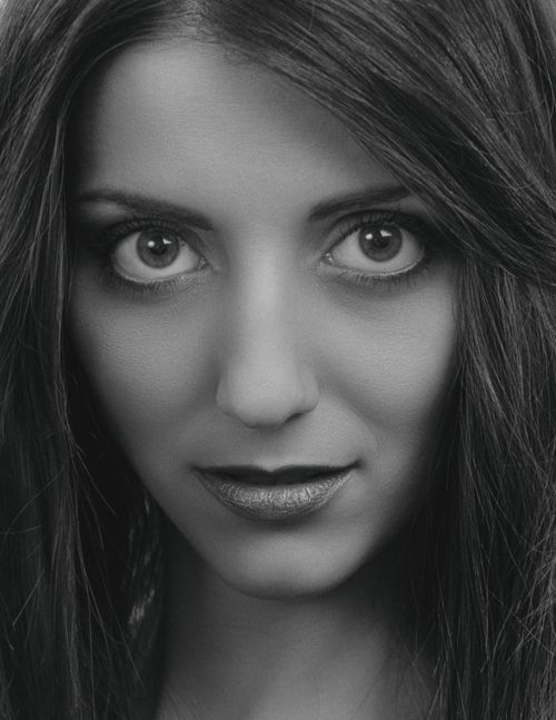 Free Close-up grayscale headshot of a woman's face with intense eyes and flowing hair. Stock Photo