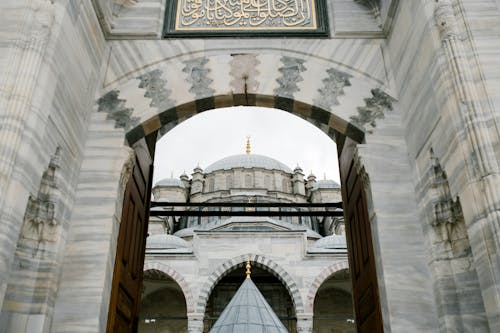 Ornamental arched entrance gate to oriental mosque in daylight