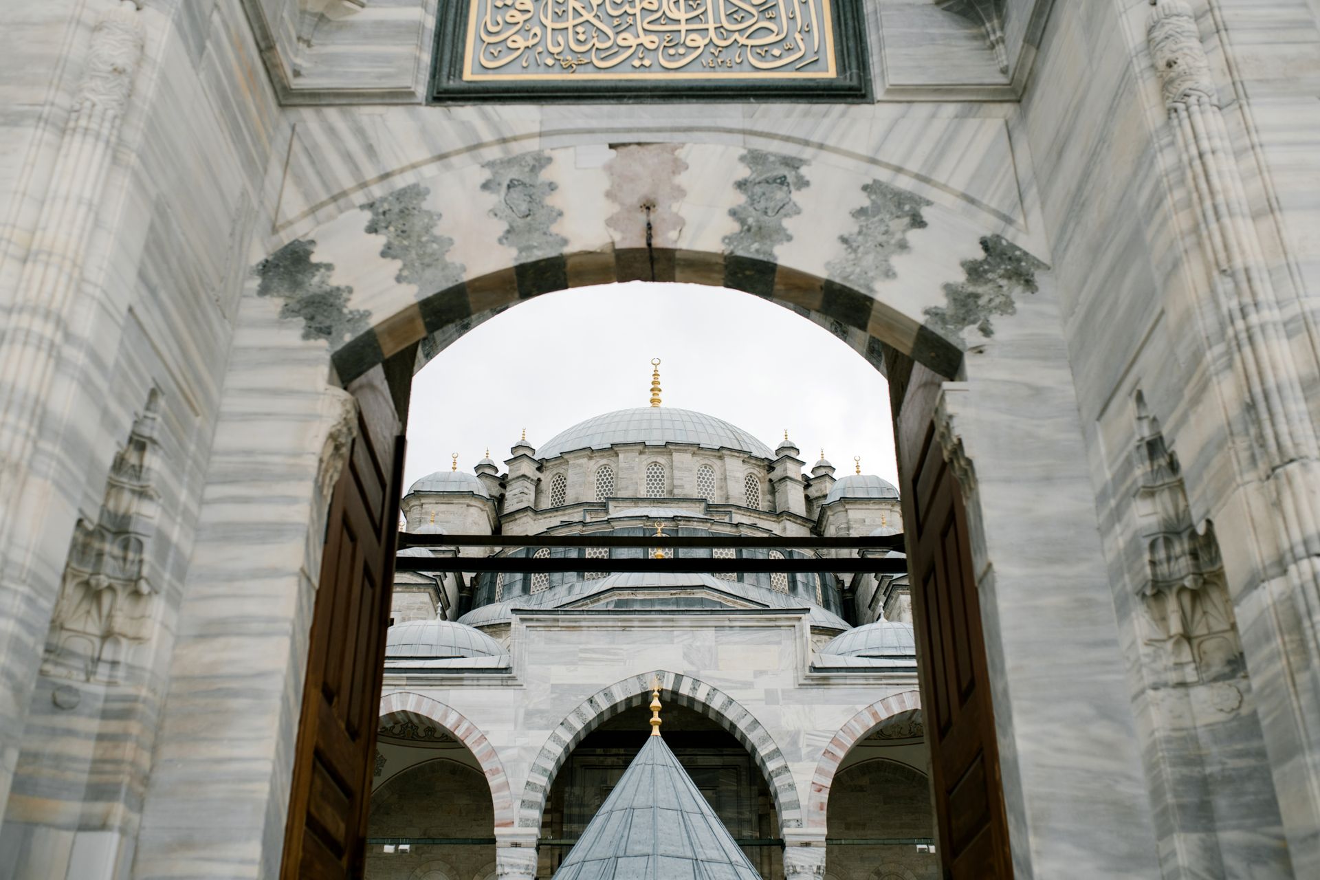 Ornamental arched entrance gate to oriental mosque in daylight