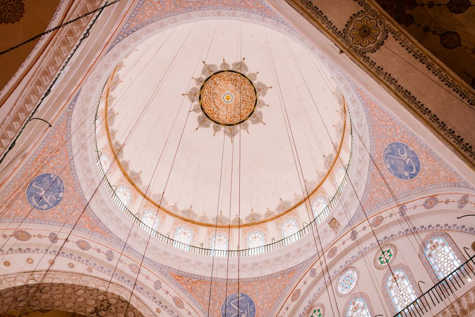 Low angle of main spacious dome with carved ornaments and colorful decoration located in Blue mosque Istanbul Turkey in daylight